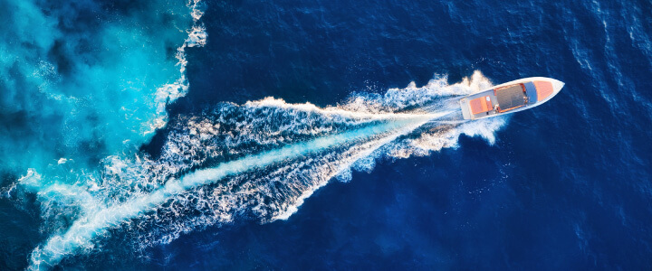Aerial view of power boat driving on blue sea